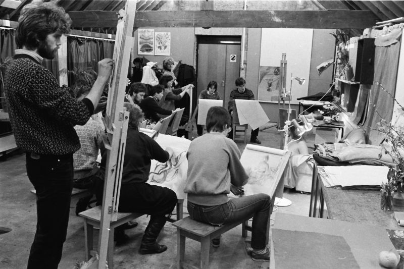 Students in a life drawing class drawing on easels