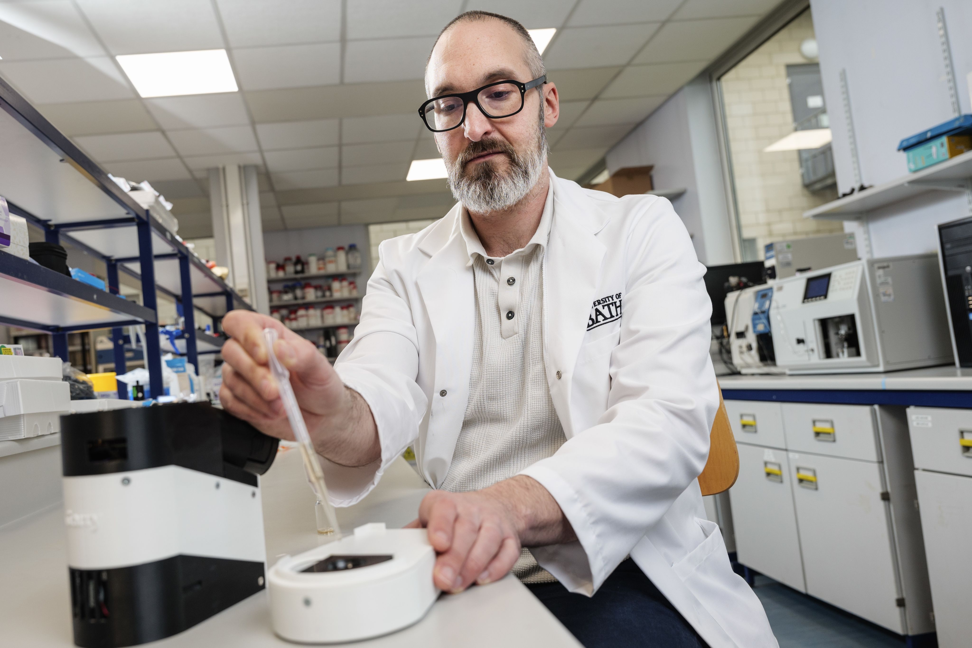 Professor Chris Pudney holding a pipette in the lab